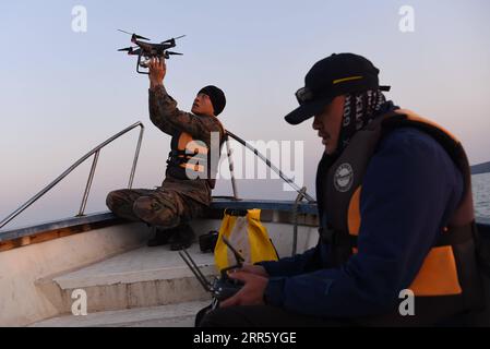 210119 -- BEIHAI, Jan. 19, 2021 -- Members in the documentary group take control of the drone after seeing the Bryde s whale in waters off Weizhou Island in south China s Guangxi Zhuang Autonomous Region, Jan. 13, 2021. The Bryde s whale, mainly seen in tropical and subtropical waters, is regarded as a very mysterious species of cetaceans, with a body length of 10 to 12 meters and a weight of up to 15 tons. A scientific research team, composed by scientists, videographers, fishermen and volunteers, has been conducting research on the whales and taking the role of the guardians of these marine Stock Photo