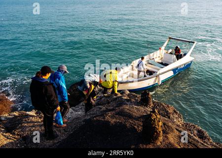 210119 -- BEIHAI, Jan. 19, 2021 -- Members of the research team are ready to leave by boat after inspecting the observation point on Xieyang Island in Beibu Gulf, south China s Guangxi Zhuang Autonomous Region, Jan. 14, 2021. The Bryde s whale, mainly seen in tropical and subtropical waters, is regarded as a very mysterious species of cetaceans, with a body length of 10 to 12 meters and a weight of up to 15 tons. A scientific research team, composed by scientists, videographers, fishermen and volunteers, has been conducting research on the whales and taking the role of the guardians of these m Stock Photo