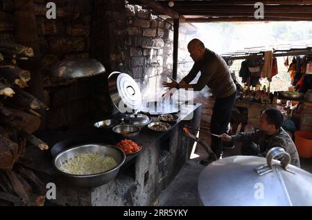 210119 -- BEIHAI, Jan. 19, 2021 -- Xu Jian, a nature documentary videographer, cooks for the research team at their station on Xieyang Island in Beibu Gulf, south China s Guangxi Zhuang Autonomous Region, Jan. 14, 2021. The Bryde s whale, mainly seen in tropical and subtropical waters, is regarded as a very mysterious species of cetaceans, with a body length of 10 to 12 meters and a weight of up to 15 tons. A scientific research team, composed by scientists, videographers, fishermen and volunteers, has been conducting research on the whales and taking the role of the guardians of these marine Stock Photo
