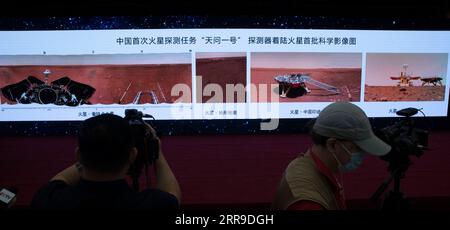 210611 -- BEIJING, 11 de junio de 2021 -- Periodistas trabajan en la ceremonia durante la cual se presentan nuevas imágenes tomadas por el primer Mars rover Zhurong de China en Beijing, capital de China, el 11 de junio de 2021. La Administración Espacial Nacional de China, CNSA, publicó el viernes nuevas imágenes tomadas por el primer rover de Marte Zhurong del país, mostrando la bandera nacional en el planeta rojo. Las imágenes fueron reveladas en una ceremonia en Beijing, lo que significa el éxito total de la primera misión de exploración de Marte de China. Las imágenes incluyen el panorama del lugar de aterrizaje, el paisaje marciano y una selfie del rover con la plataforma de aterrizaje Foto de stock