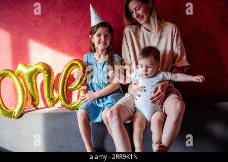 Familia joven feliz celebra el primer cumpleaños del niño el bebé