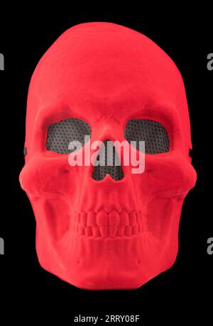 Máscara de cráneo de terciopelo rojo aislado contra fondo negro Foto de stock