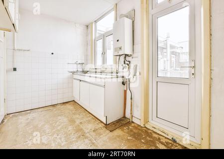 Pequeño Interior De Cocina Bien Organizado Con Fregadero Bajo La Ventana Y  Muebles Ligeros Con Estufa Y Nevera En Un Apartamento Urbano Fotos,  retratos, imágenes y fotografía de archivo libres de derecho.