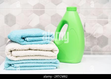 Pila de toallas de baño y detergente. Toallas limpias en la lavandería o el baño. Foto de stock