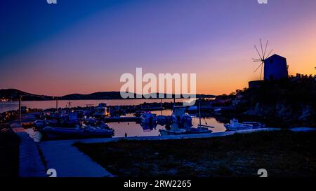 Barcos de pesca idílicos de colores claros en el muelle a la hora de la puesta del sol Foto de stock