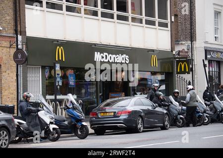 Uxbridge, Reino Unido. 18 de septiembre de 2023. Los conductores de comida a domicilio esperan el próximo pedido para entregar fuera de un restaurante McDonald's en Uxbridge, en el distrito londinense de Hillingdon. Crédito: Maureen McLean/Alamy Foto de stock