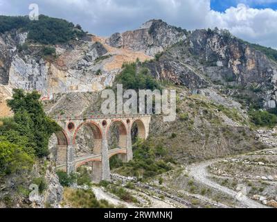 puente sobre el río en las montañas de mármol de carrara en italia Foto de stock