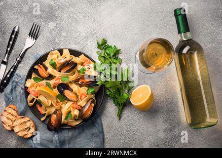 Mejillones, tostadas de pan y vino blanco en mesa de piedra. Vista superior con espacio de copia. Foto de stock
