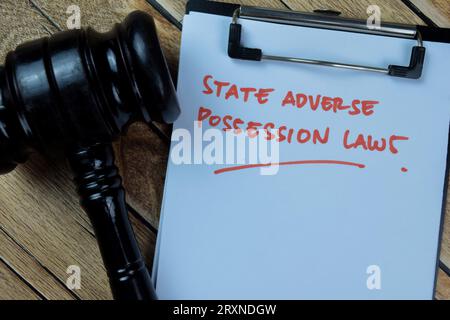 Concepto de las leyes de posesión adversa del Estado escriben en el papeleo aislado en la mesa de madera. Foto de stock