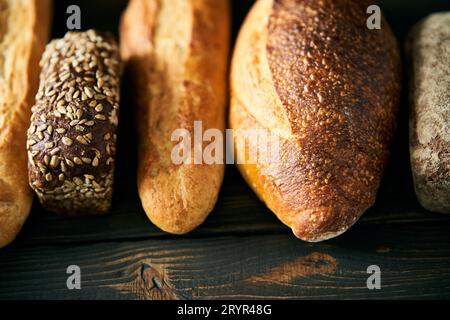 Varios panes frescos de pan sobre fondo de madera Foto de stock
