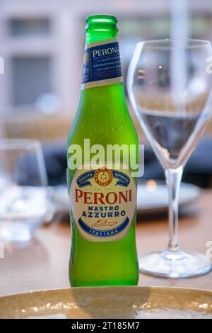 Botella de una cerveza fría Peroni Nastro Azzurro en una mesa de restaurante Foto de stock