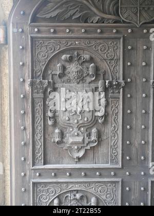 Detalle de puerta de madera con escudo de armas en la entrada de la casa solariega Lanhydrock en Cornwall Inglaterra Foto de stock