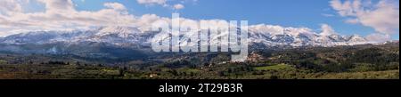 Foto panorámica, Lefka Ori en invierno, montañas blancas, pueblo, nubes, olivares verdes, provincia de Chania, Creta, Grecia Foto de stock