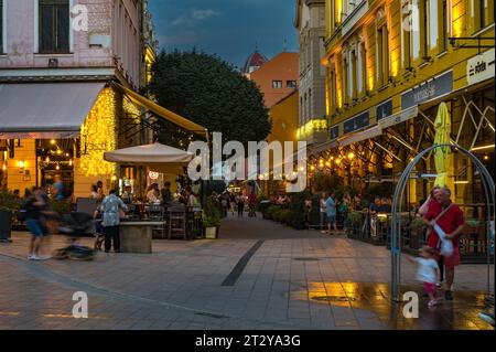 PECS, HUNGRÍA - 17 DE AGOSTO de 2022: Plaza principal - Szechenyi - Por la noche en Pecs, vista en la calle Kiraly Foto de stock