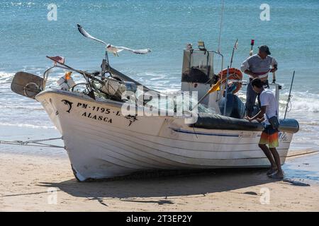 Portugal, Algarve, Armacao de Pera: Captura del día. Barco de pesca en la playa Foto de stock