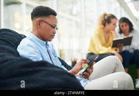 Creativos en su hábitat natural. un joven hombre de negocios usando una tableta digital en una oficina moderna. Foto de stock