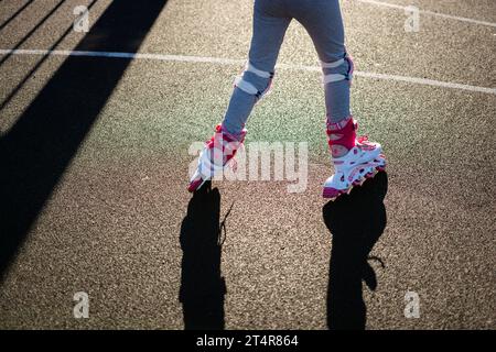 Una niña aprende a deslizarse por la calle de la ciudad. Seguro con casco y  protecciones para codos, muñecas y rodillas. Conceptos: Diversión, s  Fotografía de stock - Alamy