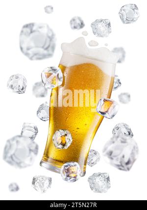 Copa de cerveza rodeada de cubitos de hielo voladores. Imagen conceptual de vidrio de cerveza enfriando. Foto de stock