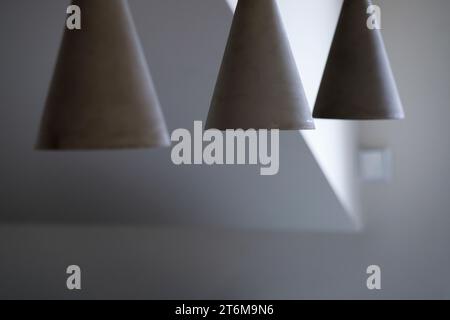 Luces modernas de hormigón. Conjunto de tres luces de techo minimalistas grises en la sala de estar. Foto de stock