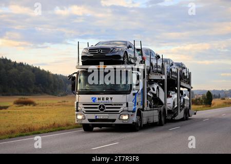 El camión portaautomóviles Mercedes-Benz Hert Transport transporta nuevos coches a lo largo de la carretera en el sur de Finlandia temprano en la mañana de otoño. Salo, Finlandia. 23 de septiembre de 2022 Foto de stock