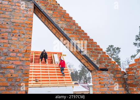 Irpin - Ucrania, marzo - 13, 2021: Ventana, dintel de metal de la puerta con la barra de hierro en ladrillo construcción de la casa sin terminar. Contratista de techos. Foto de stock
