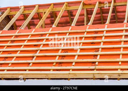 Irpin - Ucrania, Marzo - 13, 2021: Instalación de tableros de techo y barreras de vapor para baldosas metálicas en invierno. Foto de stock