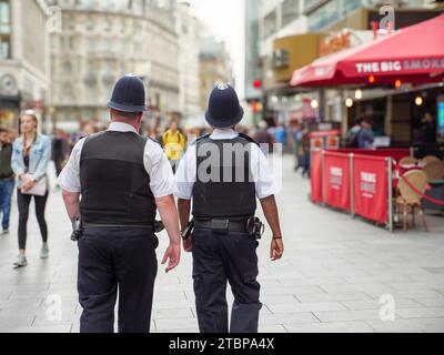 Dos policías metropolitanos patrullan en las calles del West End, Londres, Reino Unido Foto de stock