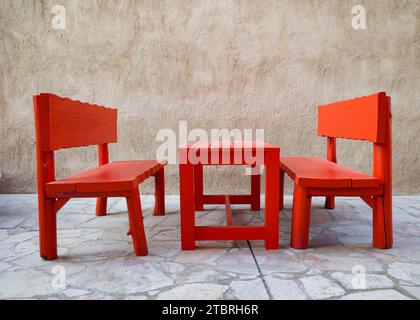 Una mesa de picnic de madera roja y bancos en el distrito histórico de Al Fahidi, Dubai, Emiratos Árabes Unidos. Foto de stock