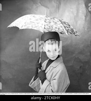 mujer de los años 1950 con paraguas. Una mujer joven sostiene un paraguas. 1958. Kristoffersson ref DB73-5 Foto de stock
