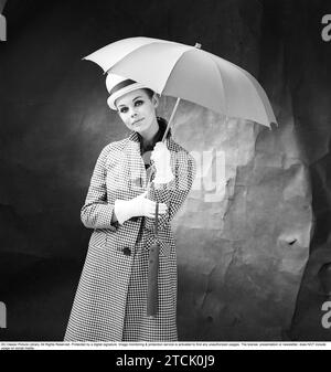 mujer de los años 1950 con paraguas. Una mujer joven sostiene un paraguas. 1958. Kristoffersson ref DB75-5 Foto de stock