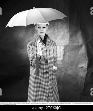 mujer de los años 1950 con paraguas. Una mujer joven sostiene un paraguas. 1958. Kristoffersson ref DB75-12 Foto de stock