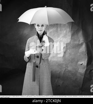 mujer de los años 1950 con paraguas. Una mujer joven sostiene un paraguas. 1958. Kristoffersson ref DB75-6 Foto de stock