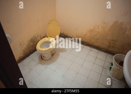 Cuarto de baño adjunto de una habitación de motel barato en Savannakhet, Laos. Inodoro con descarga de cubo. Foto de stock