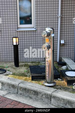 Hidrante de incendios en la calle cerca del casco antiguo de osaka Idioma japonés significa "para el departamento de bomberos". Foto de stock