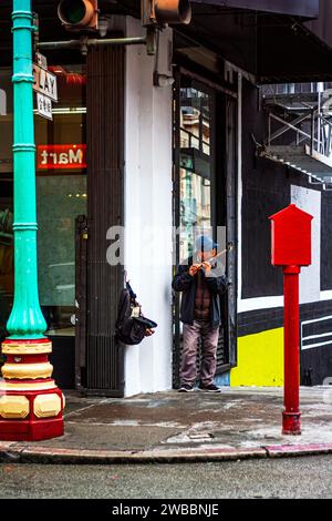 Un hombre tocando la flauta en una esquina de la calle en Chinatown en San Francisco, California Foto de stock