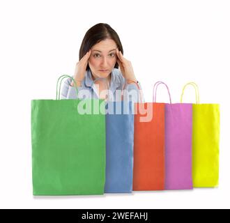 Mujer shopaholic preocupada después de múltiples compras con fondo blanco Foto de stock