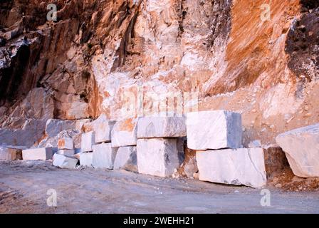 Bloques de mármol rojizo en una cantera de Carrara, al atardecer, hora azul, Toscana, Italia, Europa Foto de stock