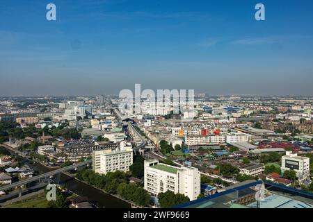 Esta foto captura el paisaje urbano panorámico de Bangkok visto desde lo alto de un edificio, mostrando la bulliciosa vida urbana y los puntos de referencia arquitectónicos Foto de stock