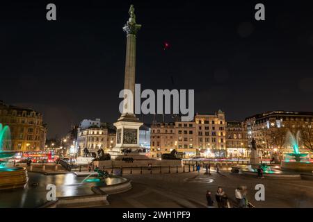 Londres. REINO UNIDO - 02.04.2024. Una vista general nocturna de Trafalgar Square que muestra la columna de Nelson y las fuentes de agua. Foto de stock