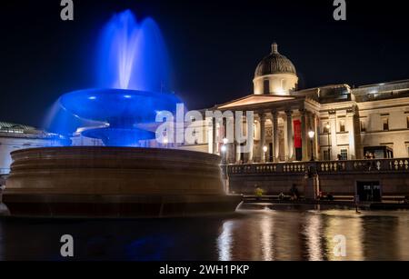 Londres. REINO UNIDO - 02.04.2024. Una vista nocturna de la Galería Nacional desde una de las fuentes de agua de Trafalgar Square. Foto de stock