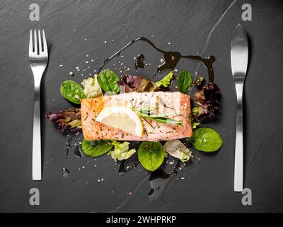 Filete de salmón a la parrilla con ensalada en negro Foto de stock