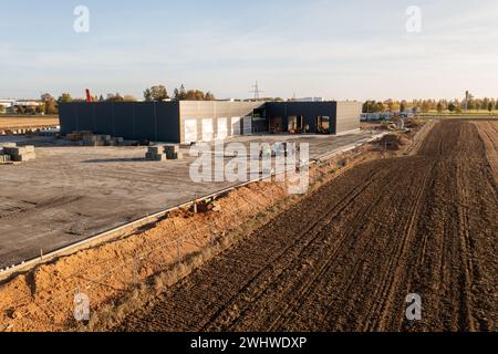 Fotografía de drones del sitio de construcción de almacenes en los campos durante el día soleado de otoño Foto de stock