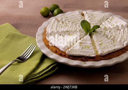 Pastel de lima clave entero con merengue y menta de cerca Foto de stock