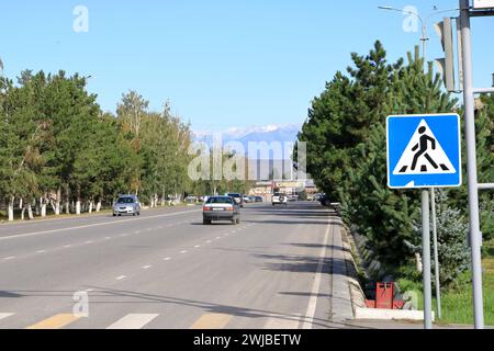 29 de agosto de 2023 - Karakol en Kirguistán: Vista sobre la calle con coches y tiendas en la pequeña ciudad Foto de stock