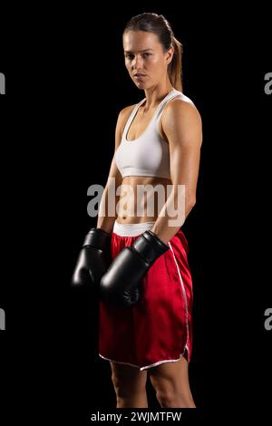 Joven mujer caucásica posa con confianza en traje de boxeo, con espacio de copia Foto de stock