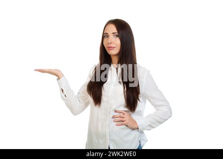 Joven, hermosa chica aislada sobre un fondo blanco señala sus manos en el lugar para las promociones, ofertas o publicidad. Foto de stock