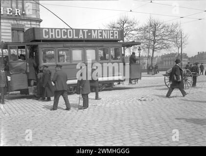 Gente caminando en una calle pavimentada en Lyon. Junto a un tranvía con publicidad. Principios del siglo XX. Vieja fotografía digitalizada de placa de vidrio Foto de stock