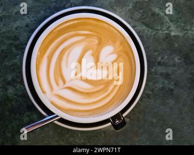 Una taza de café con espuma de leche y patrón de espuma de leche Foto de stock
