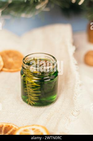 Miel verde con agujas de pino en un frasco de vidrio. Tarro de vidrio con miel sobre un fondo de atmósfera navideña. Recetas Nacionales Foto de stock