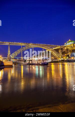 Portugal, Oporto, Distrito de Ribeira; mirando a través del río Duero por la noche hacia el puente Vila Nova de Gaia y Luís I. Foto de stock